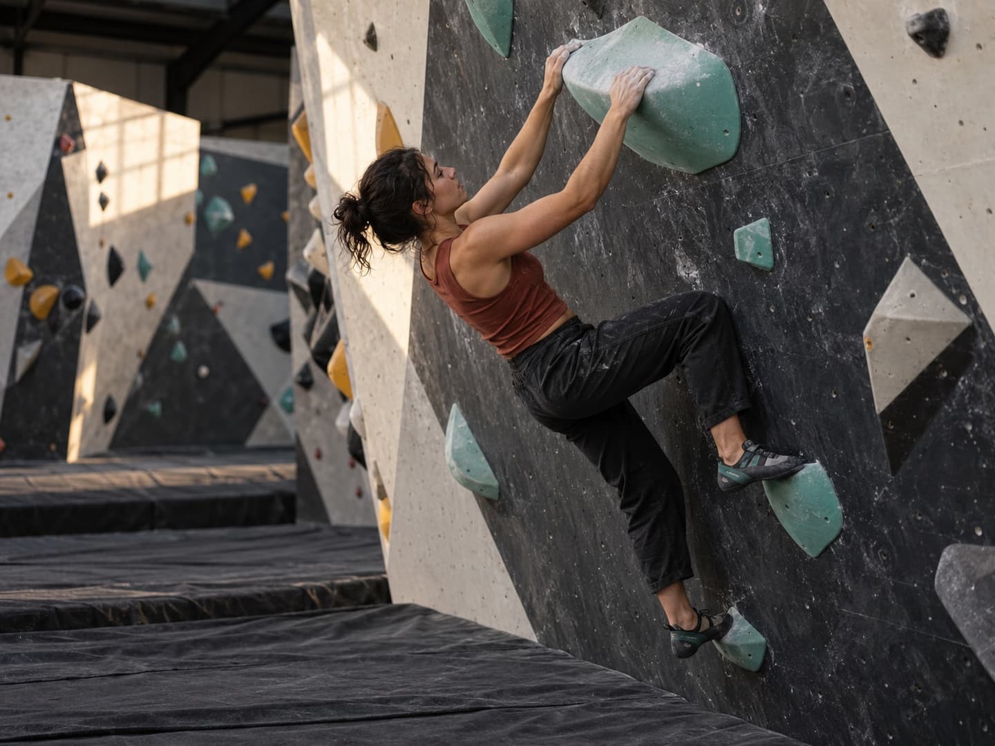 A boulderer matching a finishing hold with both feet supported on the wall